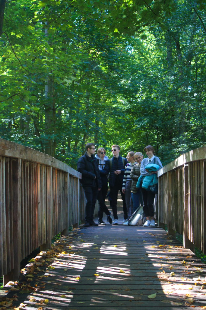 Die Schüler stehen zusammen auf einer schmalen Brücke und Lachen.