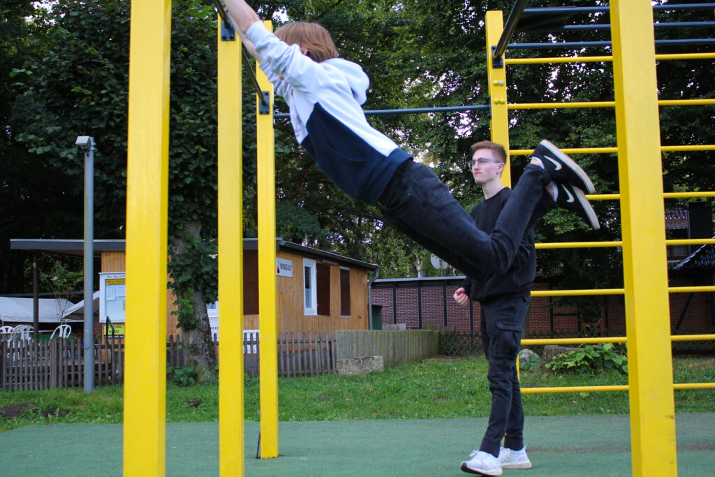 A student swings on the bars.