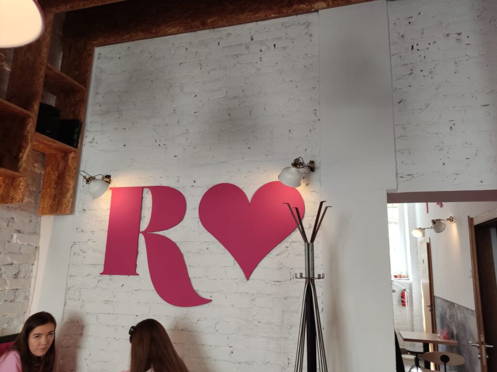 Oto zbiór zdjęć kawiarni, na których można zobaczyć różowe wnętrze.